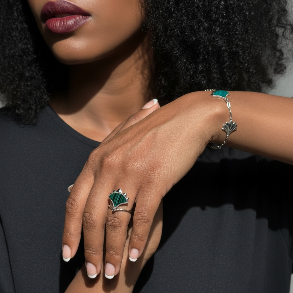 Close-up of a woman's hand wearing Dôme sterling silver ring and bracelet with natural Malachite and Zircon.
