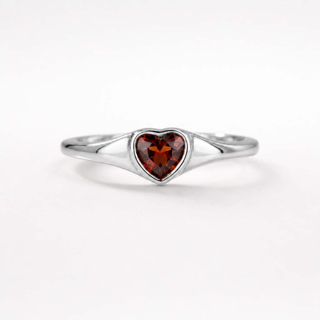 Heart-shaped garnet ring in rhodium-plated sterling silver, displayed on a neutral surface | Cirque D'Or Canada USA