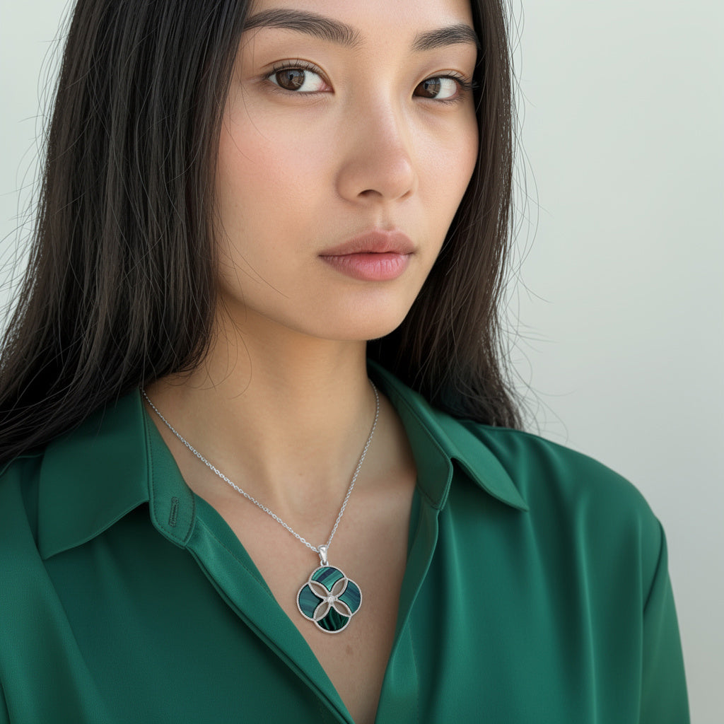 A woman wearing a green satin blouse models gold and malachite dome 4 motif pendant necklace.