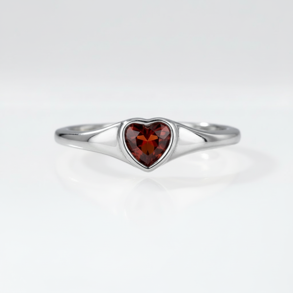 Heart-shaped garnet ring in rhodium-plated sterling silver, displayed on a neutral surface | Cirque D'Or Canada USA